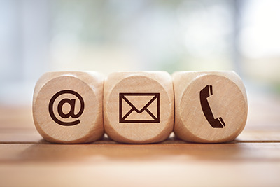 Three dice with an at symbol icon on one, a mail icon on another, and a phone icon on the last